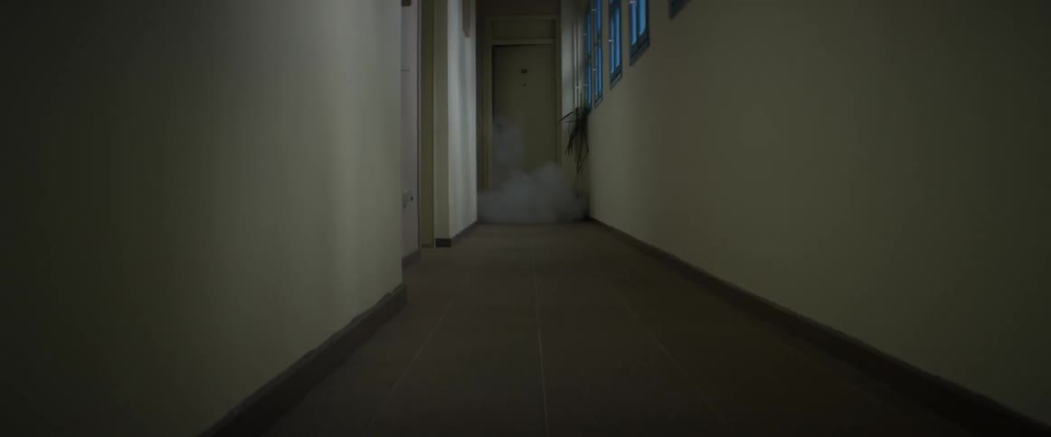 Smoke filling a hall from a room at the end