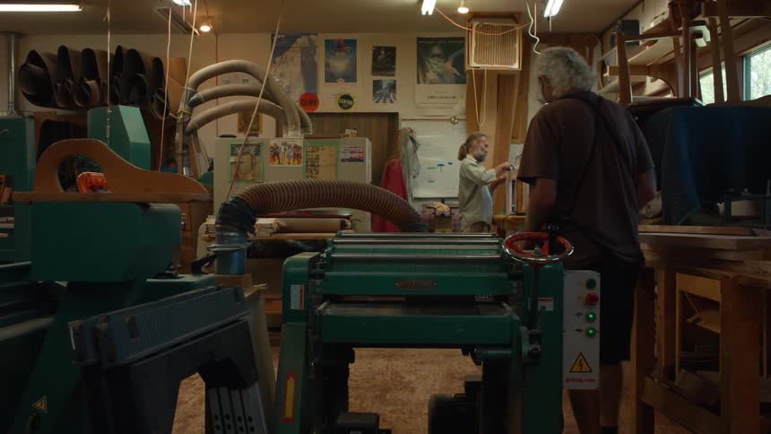 Two male carpenters working in an indoor space during the day