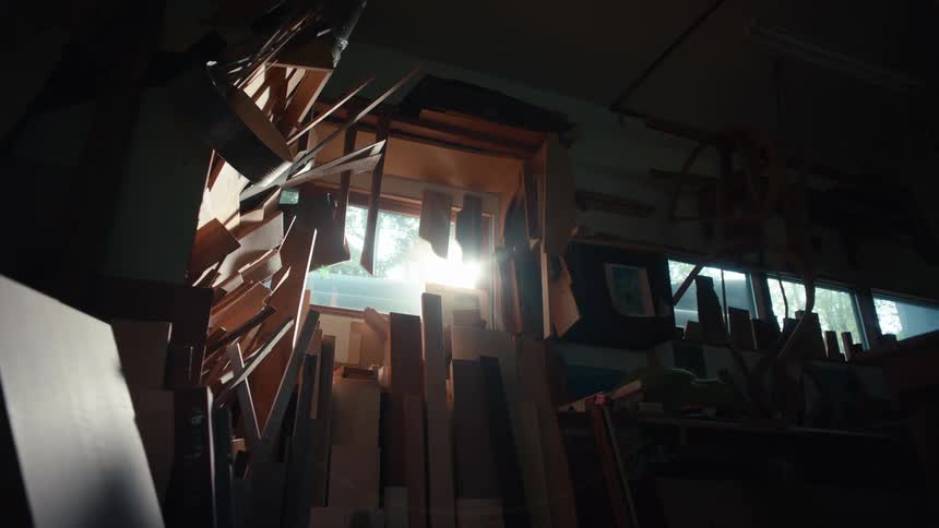 Interior view of a carpentry shop with different types of wood and cuts and the reflection of the sun coming through the window