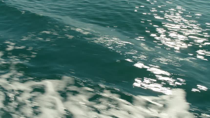 Moving view across the sea with reflection of the sun