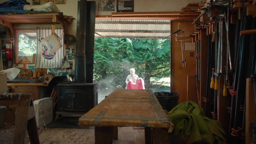 Man dusting off a red towel and placing it on the table