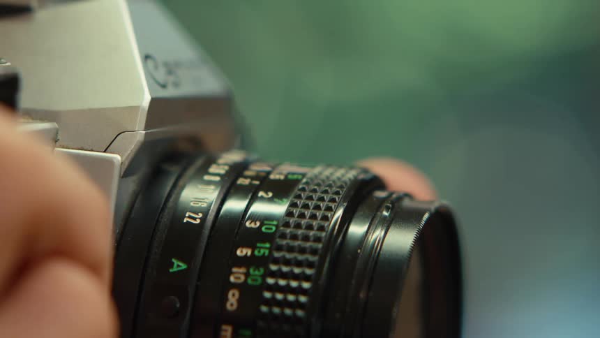 A person is adjusting the lens on a camera