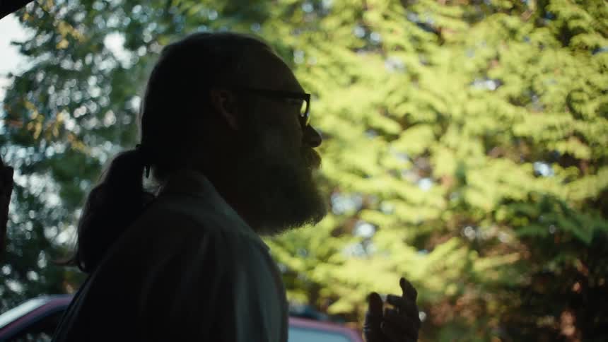 A man is talking with someone outside