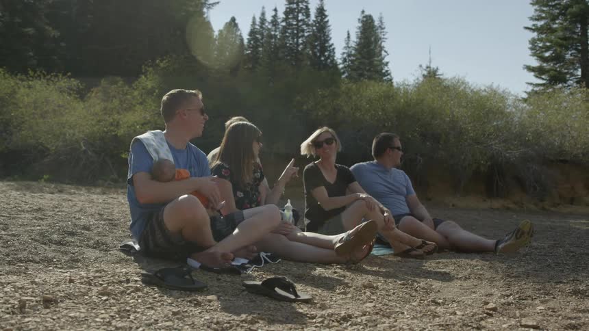 Group of people sitting on a rocky beach