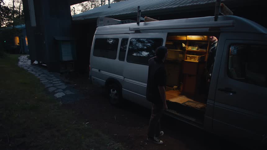 Elderly man showing a young man the inside of a motor home