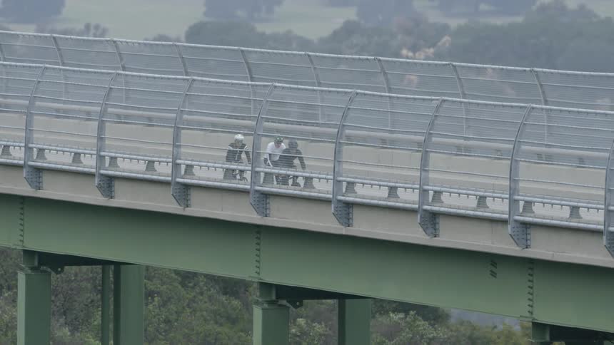 Cyclists on a bridge in slow motion