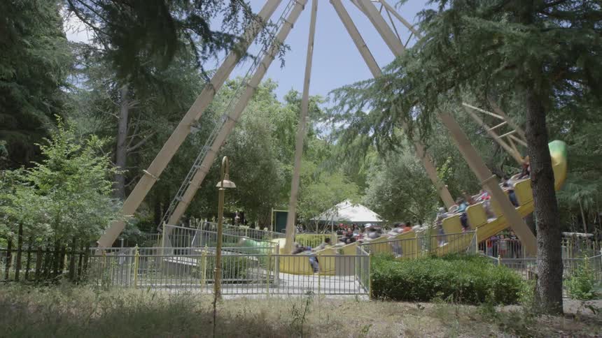 A group of people riding a boat ride that swings in a park area