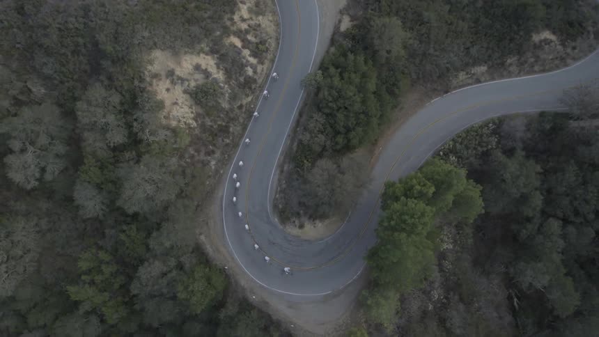 People ride their bikes below around a tight turn