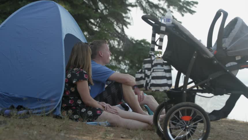 People sit down by a tent talking