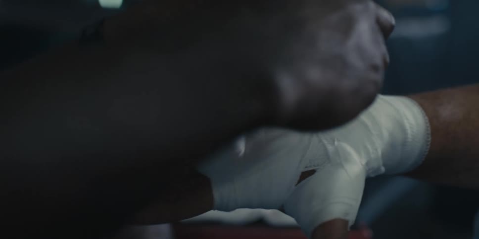 White ribbon being placed on a boxers hand