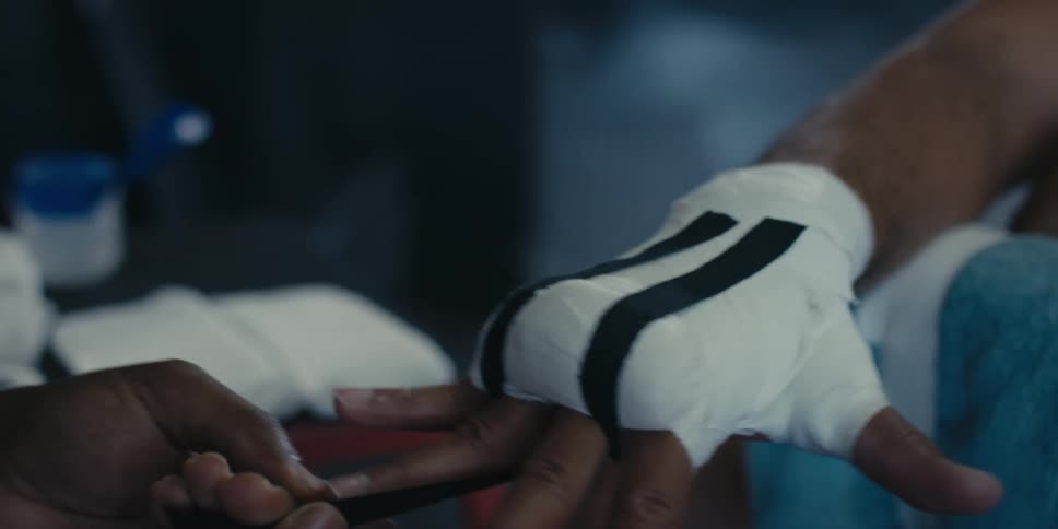 A clop of a person taping a boxers hand