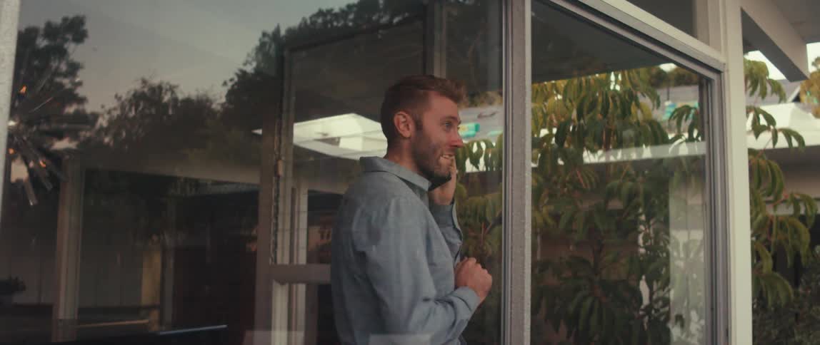 A man is walking back and forth and talking on the phone