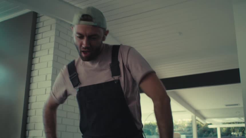 Man dances as he vacuums the floor