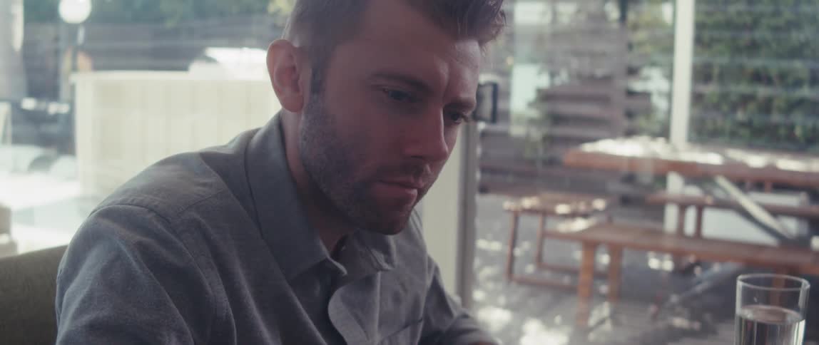 Man sitting thoughtfully working on laptop