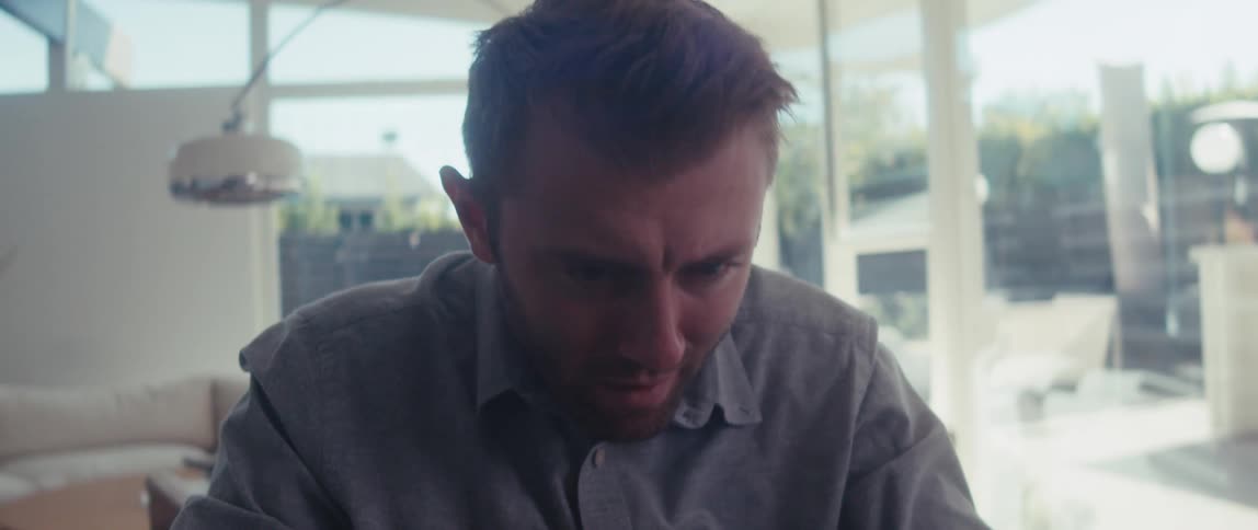 Portrait of a blond man sitting and concentrating on a laptop
