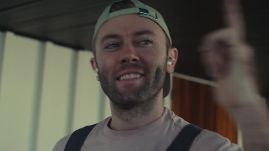 Man in cap and airpods singing and dancing
