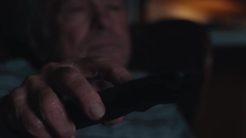 A man is using a remote control at home
