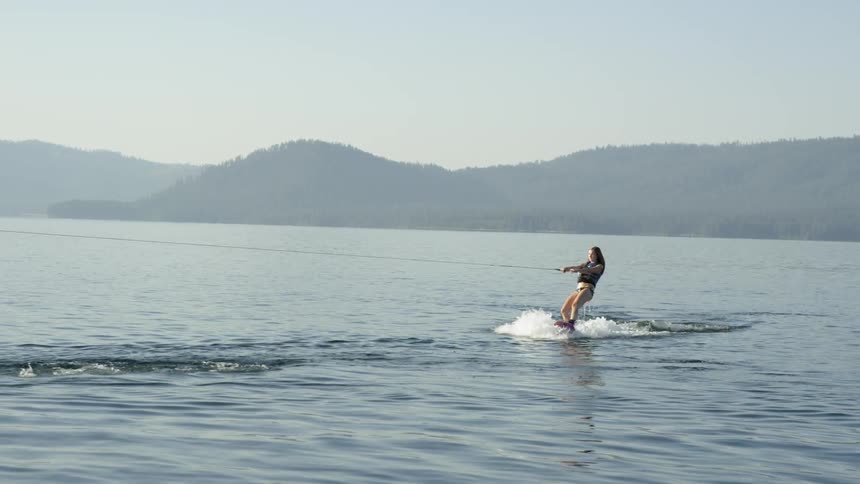 A water skier stands up on the water