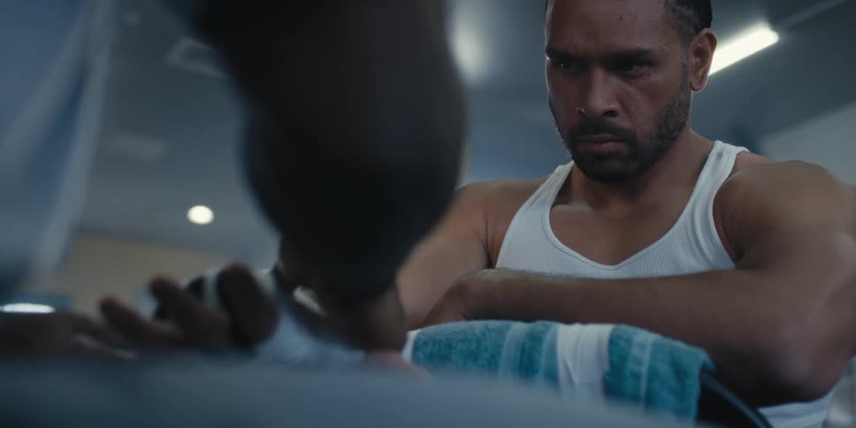 Person bandaging a fighters hand with a focused expression