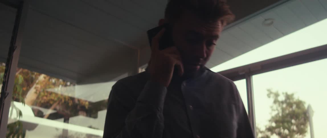 Man standing walking while on a phone call
