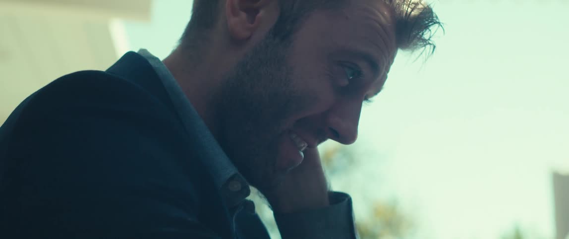 Man in blazer sitting talking