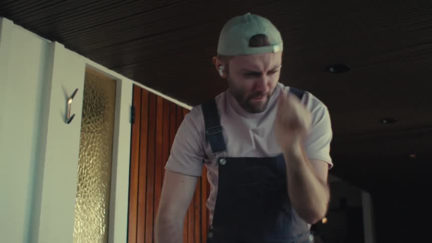 Man cleaning house with vacuum cleaner and dancing at the same time