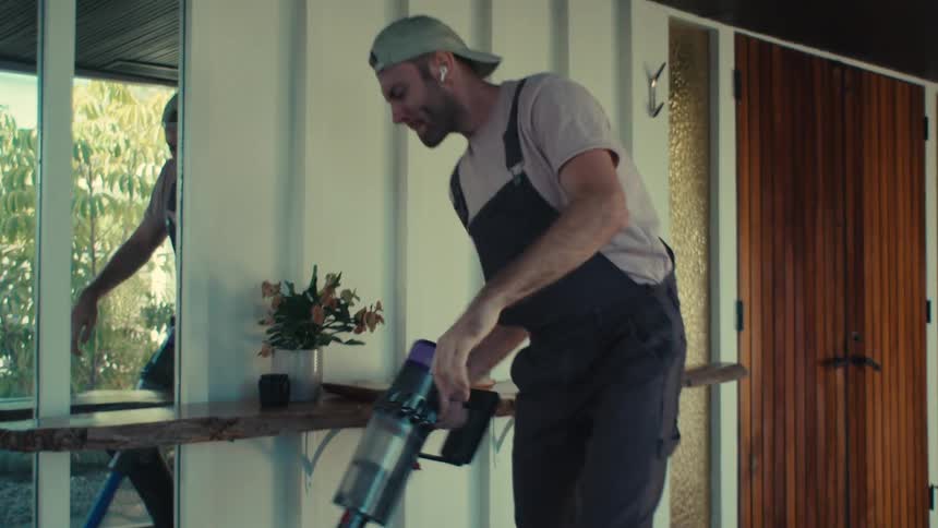 Man wearing airpods and singing and dancing while vacuuming
