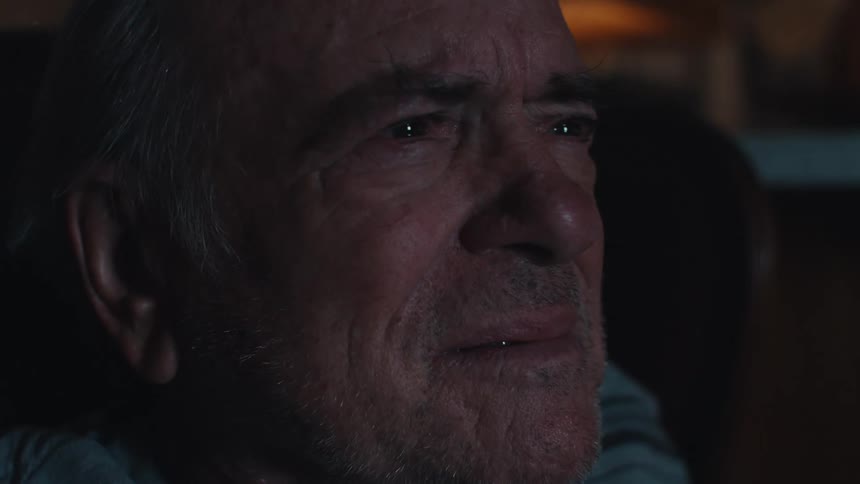 Emotional man watching TV while sitting on a chair