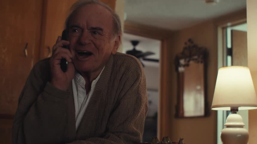 A clip of an elderly man having a conversation on phone