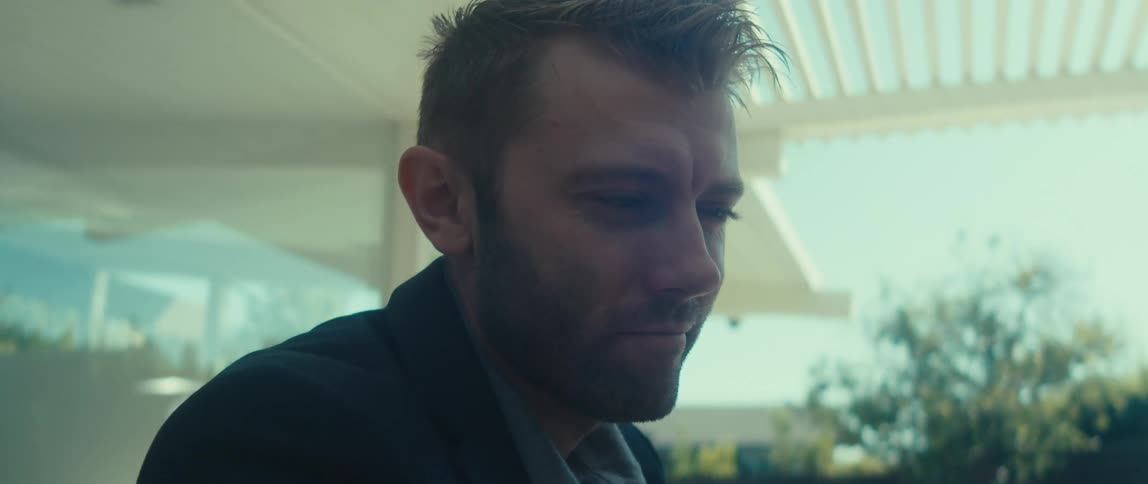 Man typing on laptop and then taking out his smartphone inside blazer