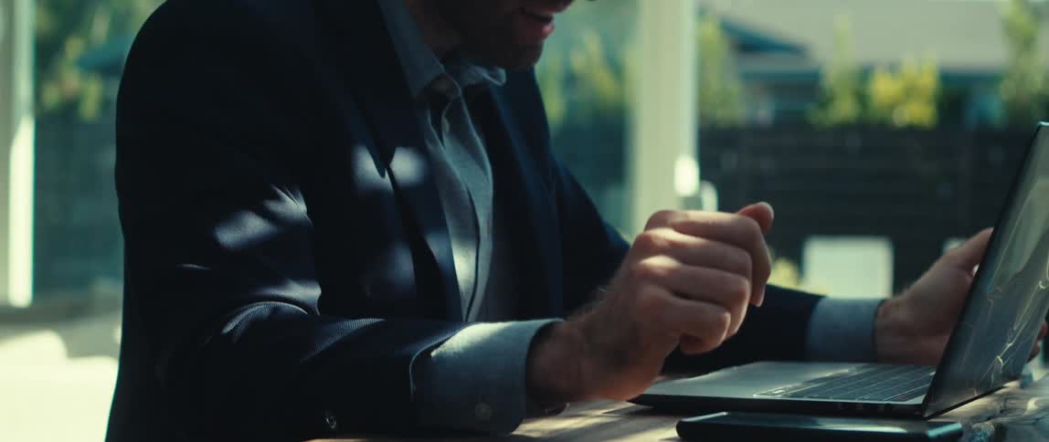 Hands of a man making gestures while sitting in front of a laptop