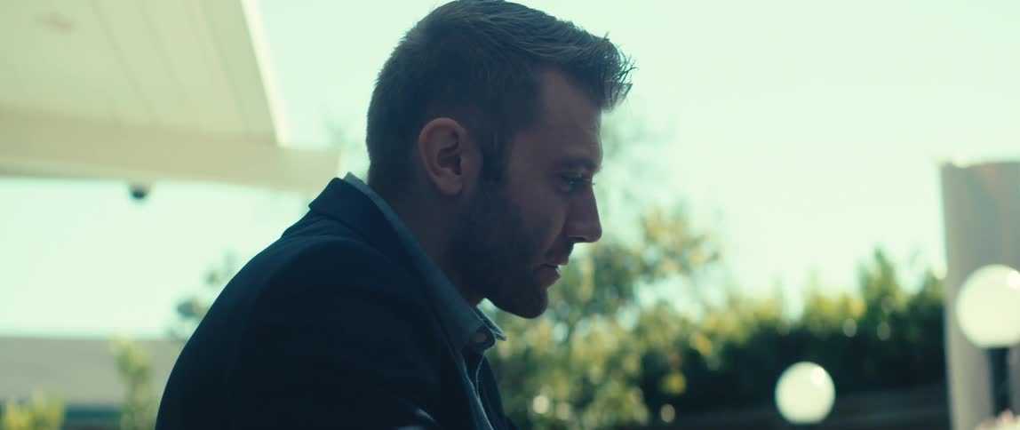 Man sitting in an outdoor area talking