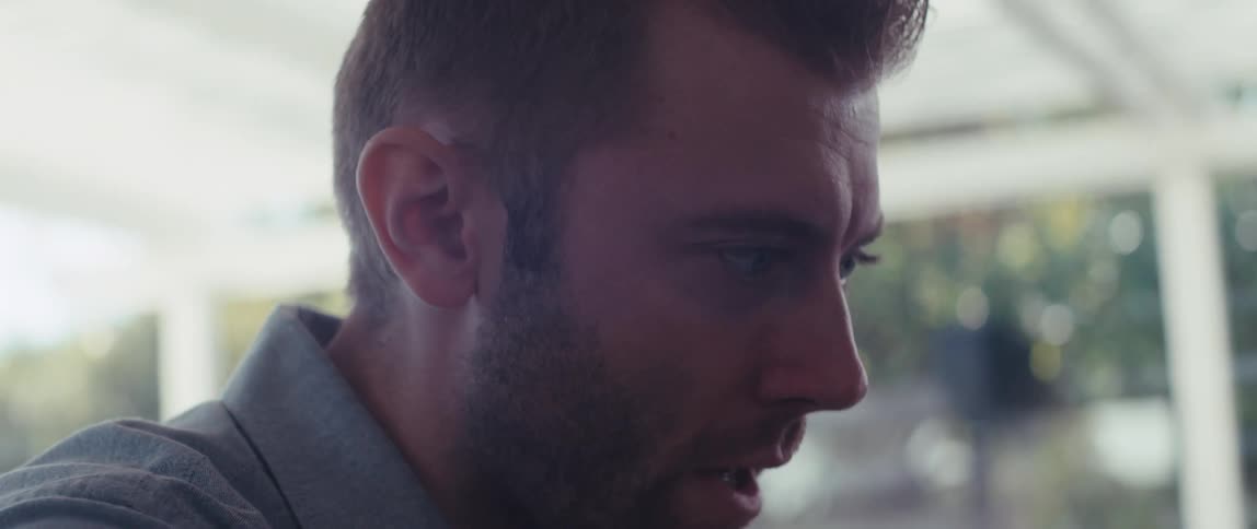 Side portrait of a man sitting at a table talking