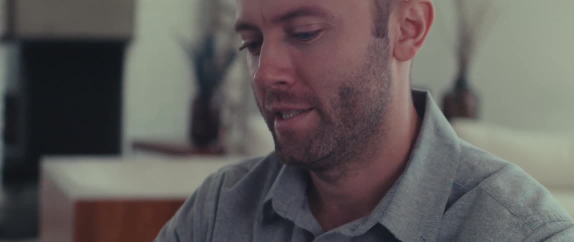 A man is talking and smiling inside