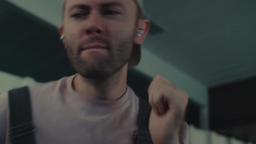 Man in cap listening to music and enjoying while dancing