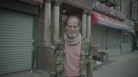 A homeless man standing outside during the day