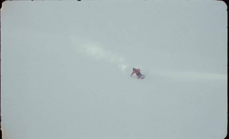 A person skiing down a hill on the white snow that is on the surface