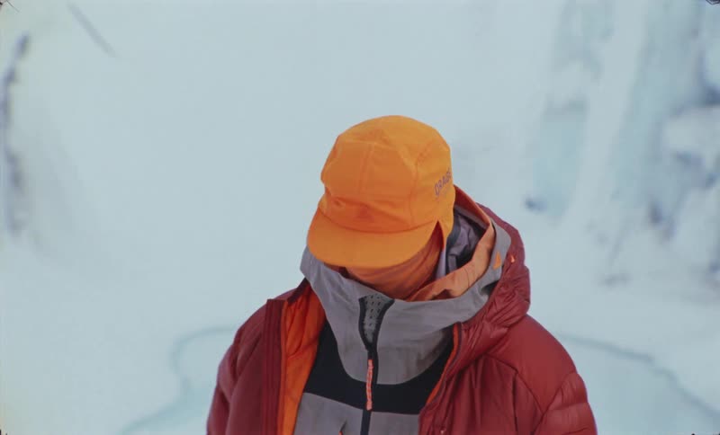 Person in winter clothes stands in an environment surrounded by glaciers and snow