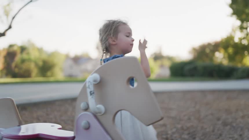 Little girl playing in an outdoor playground during the day