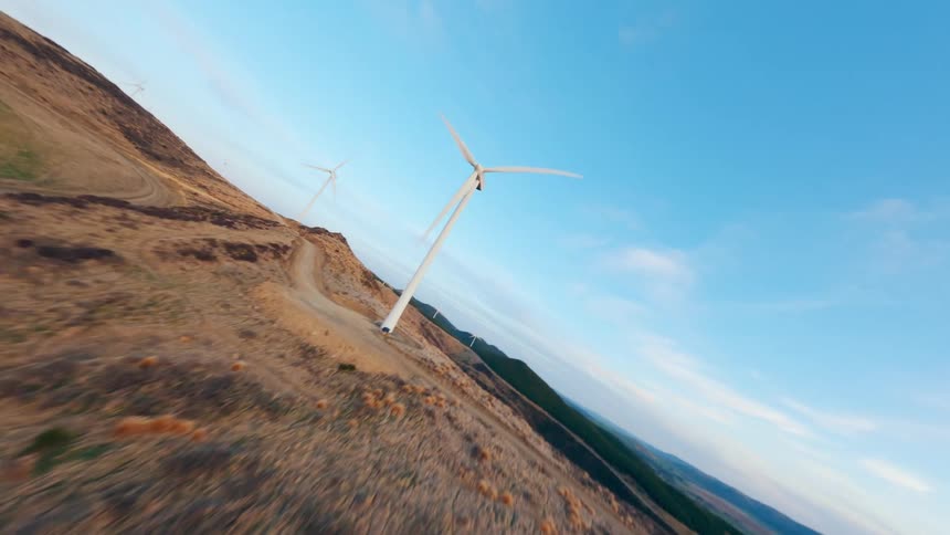 FPV Drone view of a wind farm in the mountains