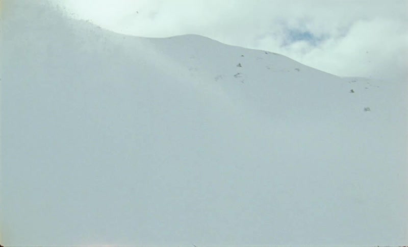A person in winter clothes and wearing a ski is skiing down a snowy mountain