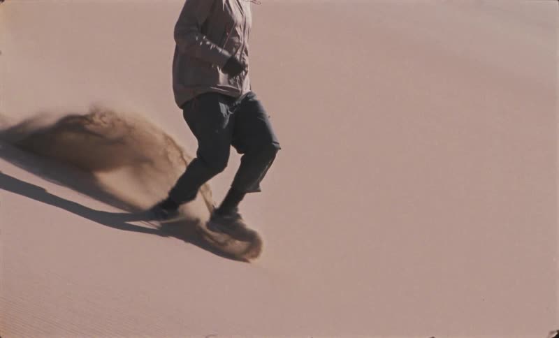 Man running down a dune in the desert