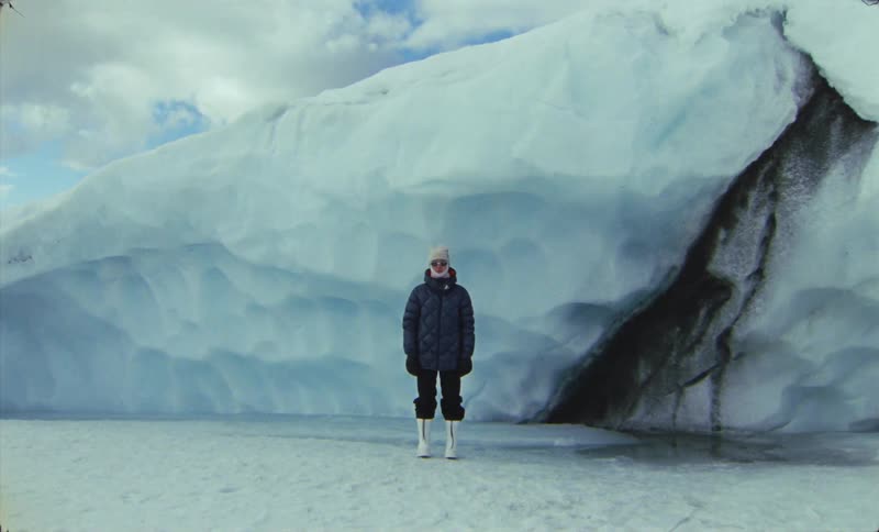 Person in winter clothes and white boots in natural environment with glaciers
