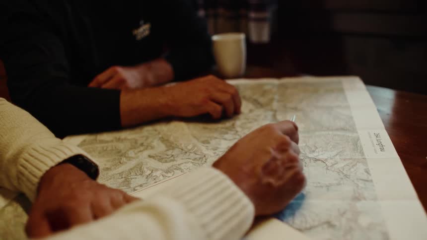 Two people sitting at a table use a map