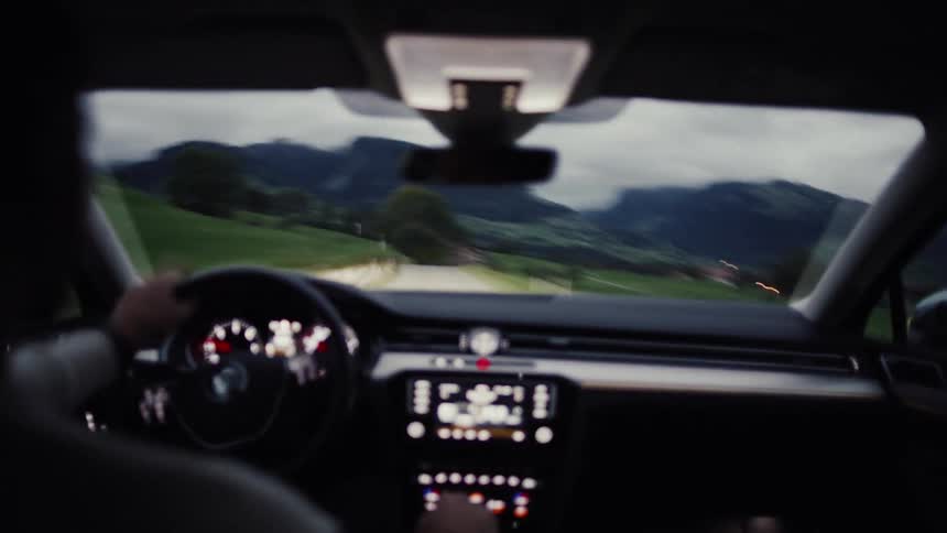 Dashboard of a car being driven by a person on a narrow road