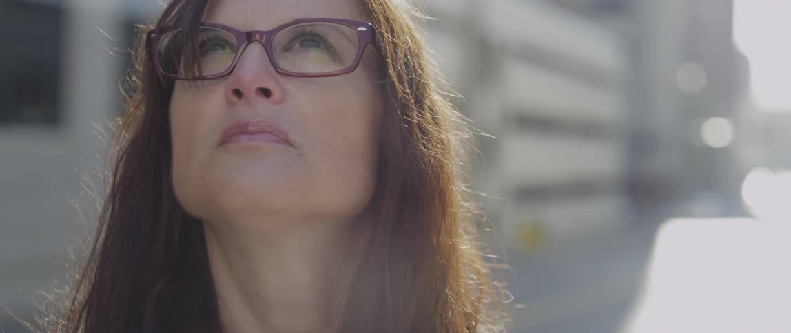 A woman in glasses looks up