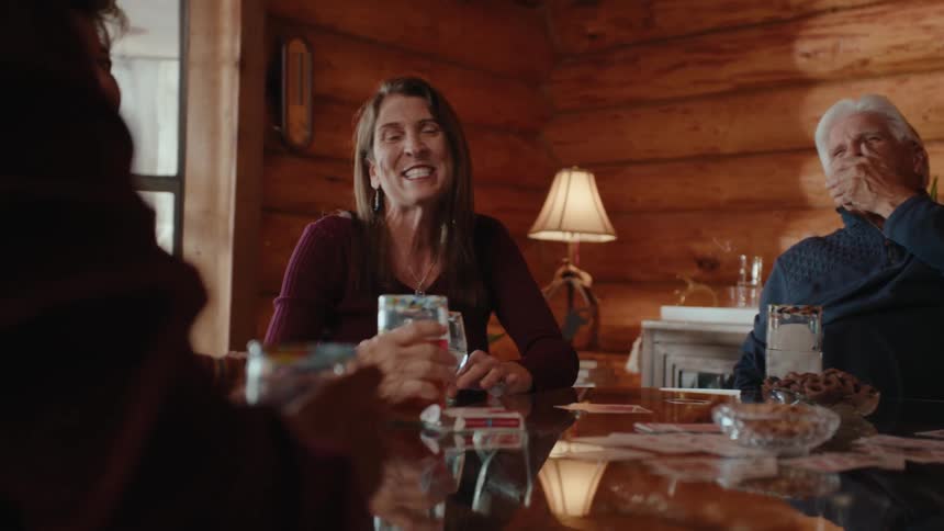 People sitting around a table drinking and talking while having fun