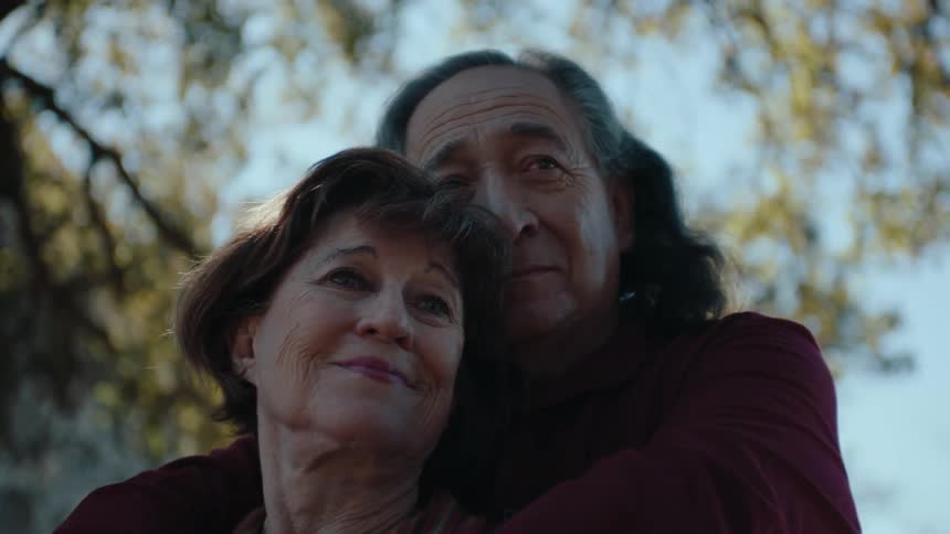 A man hugs a woman while standing outdoors