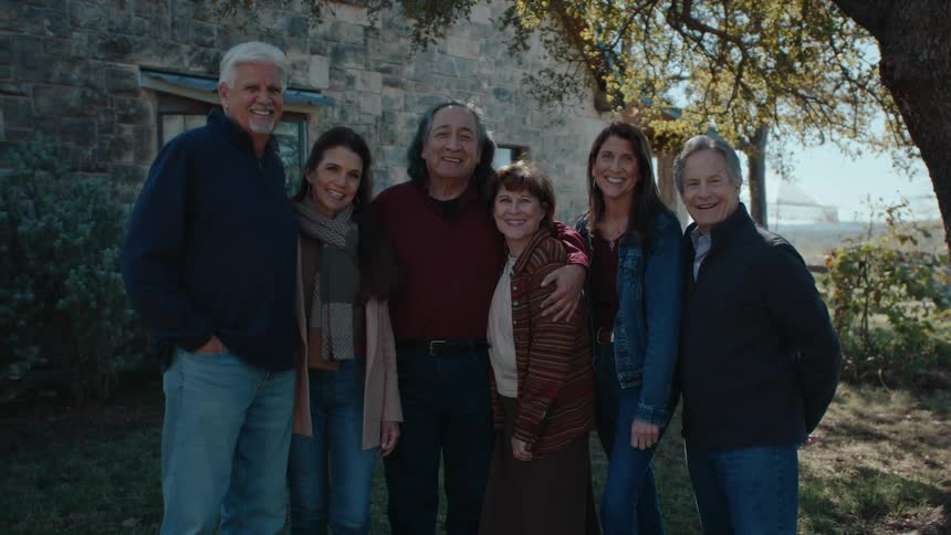 Portrait of older adult friends smiling together in front of a home in the rural outdoors