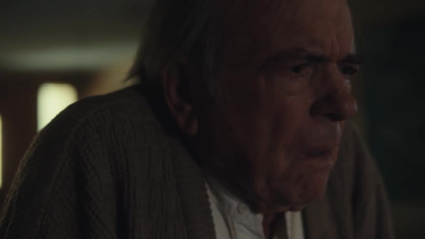 Elderly man walking down a hallway